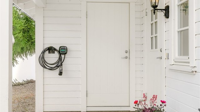 Ved inngangspartiet har boligen en utvendig bod og det er montert el bil lader