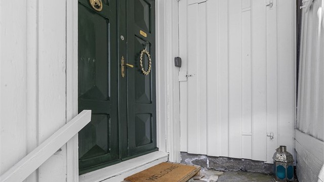 Flott dobbel entrédør med utskjæringer. Det er også en liten redskapsbod rett frem.