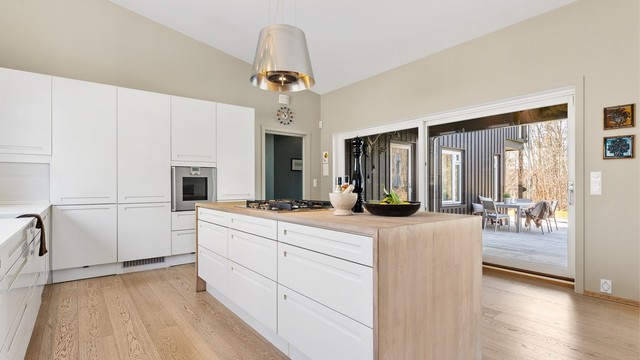 Integrerte hvitevarer: Nedfelt gassplatetopp i kjøkkenøy, stekeovn, oppvaskmaskin og kjøleskap. Ventilator fra himling med kullfilter.