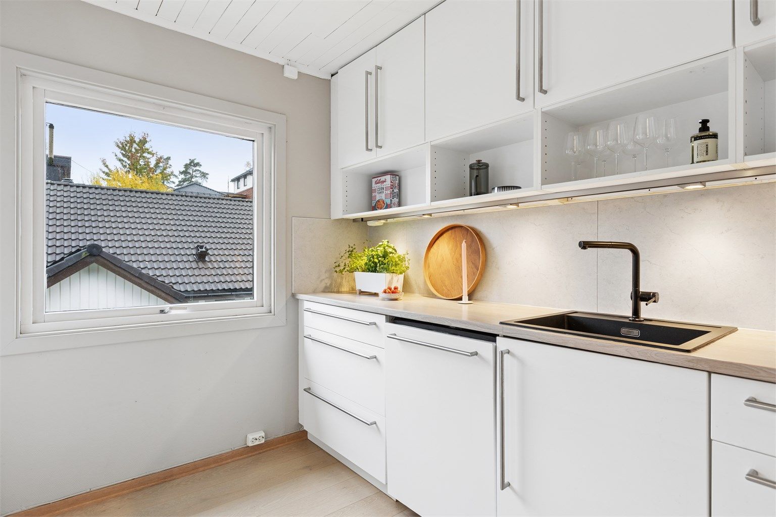 Nedfelt sort oppvaskkum med ett-greps blandebatteri og kitchenboard på vegg.
