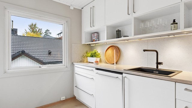 Nedfelt sort oppvaskkum med ett-greps blandebatteri og kitchenboard på vegg.