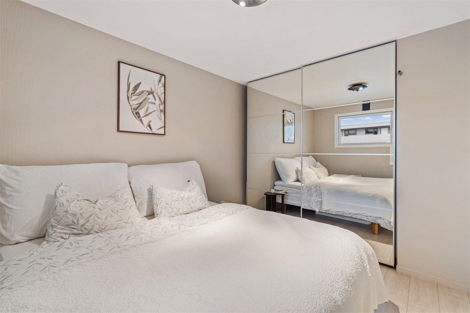 En stor skyvedørsgarderobe med speilfronter gir rikelig med oppbevaringsplass.