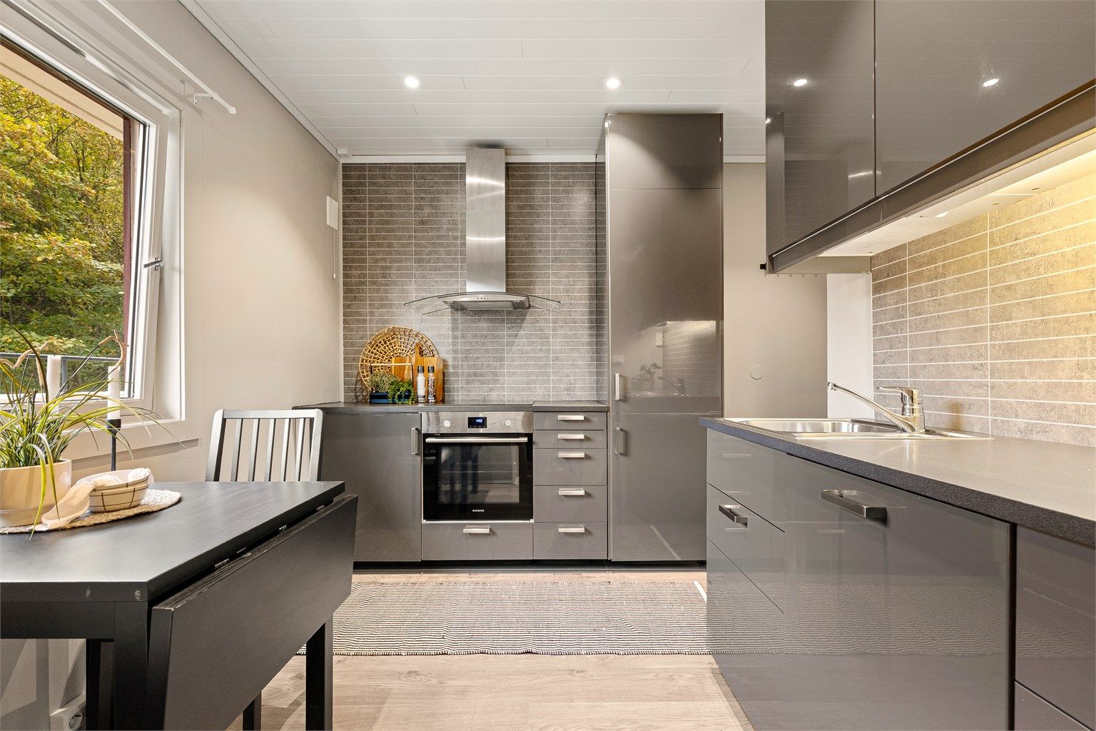 Lekkert kjøkken fra 2014 fra IKEA med glatte fronter og benkeplate med laminert overflate. Kjøkkenet har integrert  stekeovn, platetopp, oppvaskmaskin og kjøleskap med fryser.