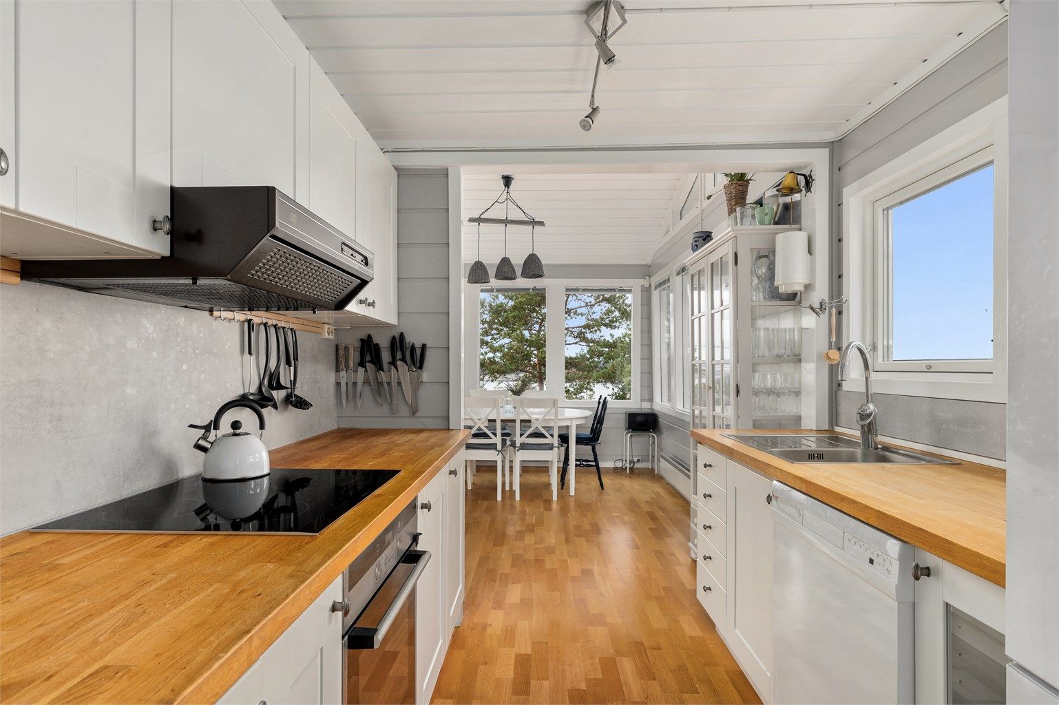 KJØKKENET Spiseplassen og stuen henger sammen i et stort allrom. Kjøkkeninnredningen  er utstyrt med integrert stekeovn, induksjon koketopp, ventilator, oppvaskmaskin og kjøl-/fryseskap.