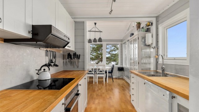 KJØKKENET Spiseplassen og stuen henger sammen i et stort allrom. Kjøkkeninnredningen er utstyrt med integrert stekeovn, induksjon koketopp, ventilator, oppvaskmaskin og kjøl-/fryseskap.