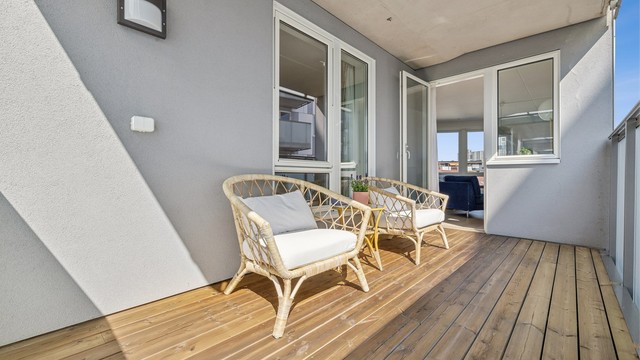 Balkongen har impregnerte terrassebord og rekkverk i stål med glassfelt.
