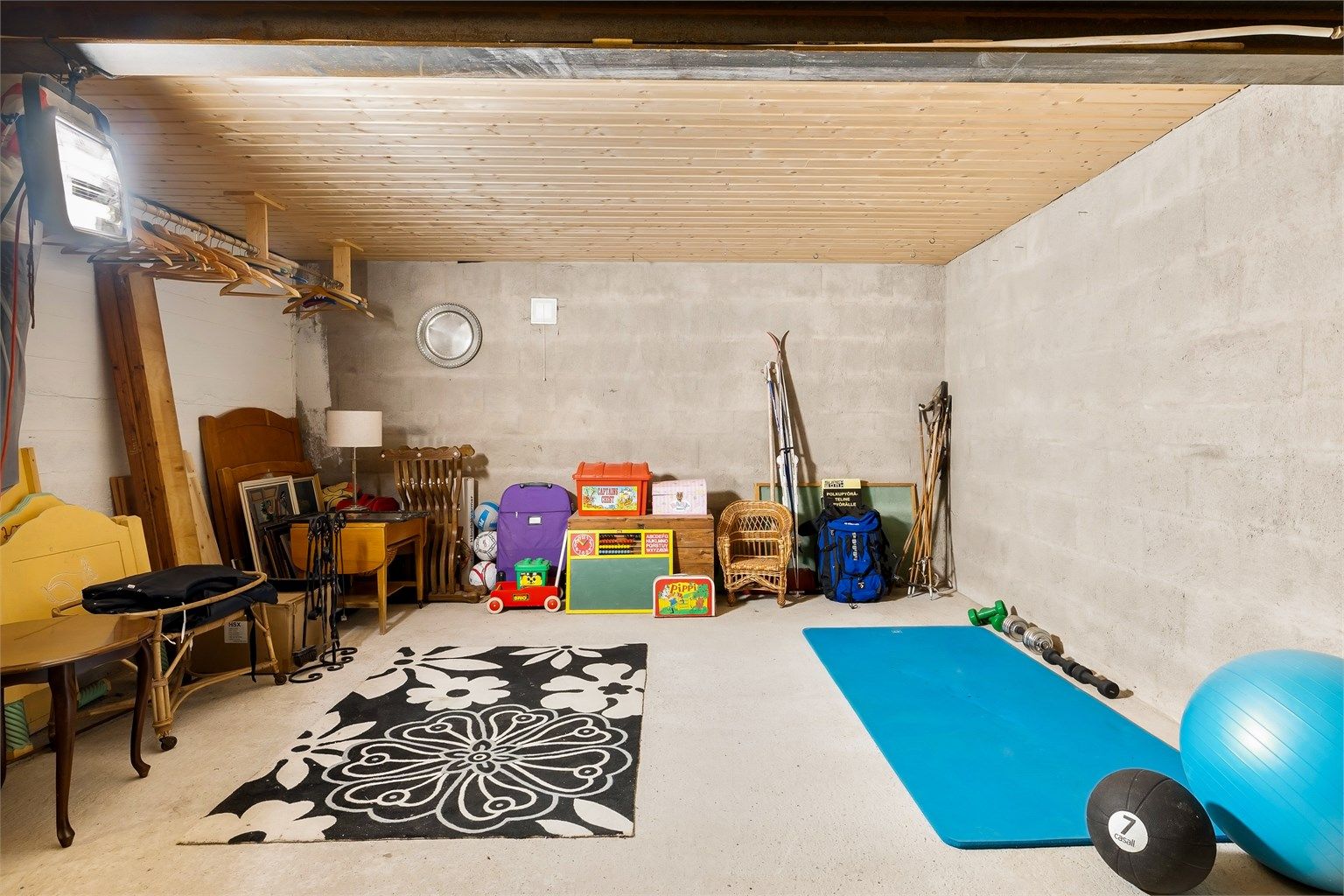Hobbyrom i kjelleren med betonggulv og panel i himling.