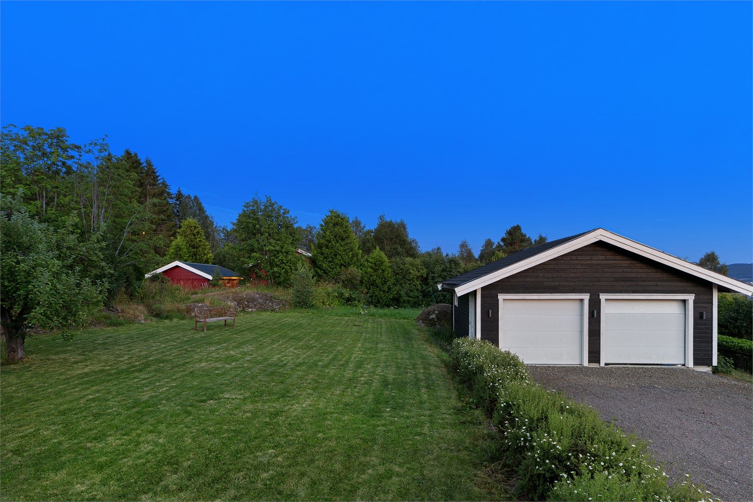 Hekk som binder huset sammen med en frittstående garasje