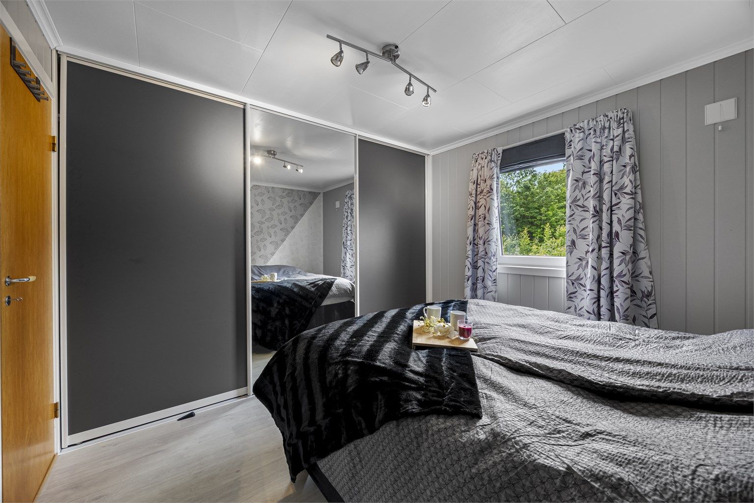 Hovedsoverommet er utstyrt med en stor skyvedørsgarderobe med speilfronter.