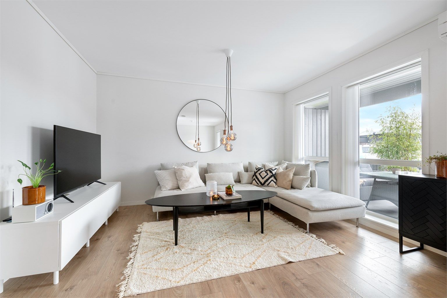 Stue med lyse overflater og utgang til stor sørvendt markterrasse