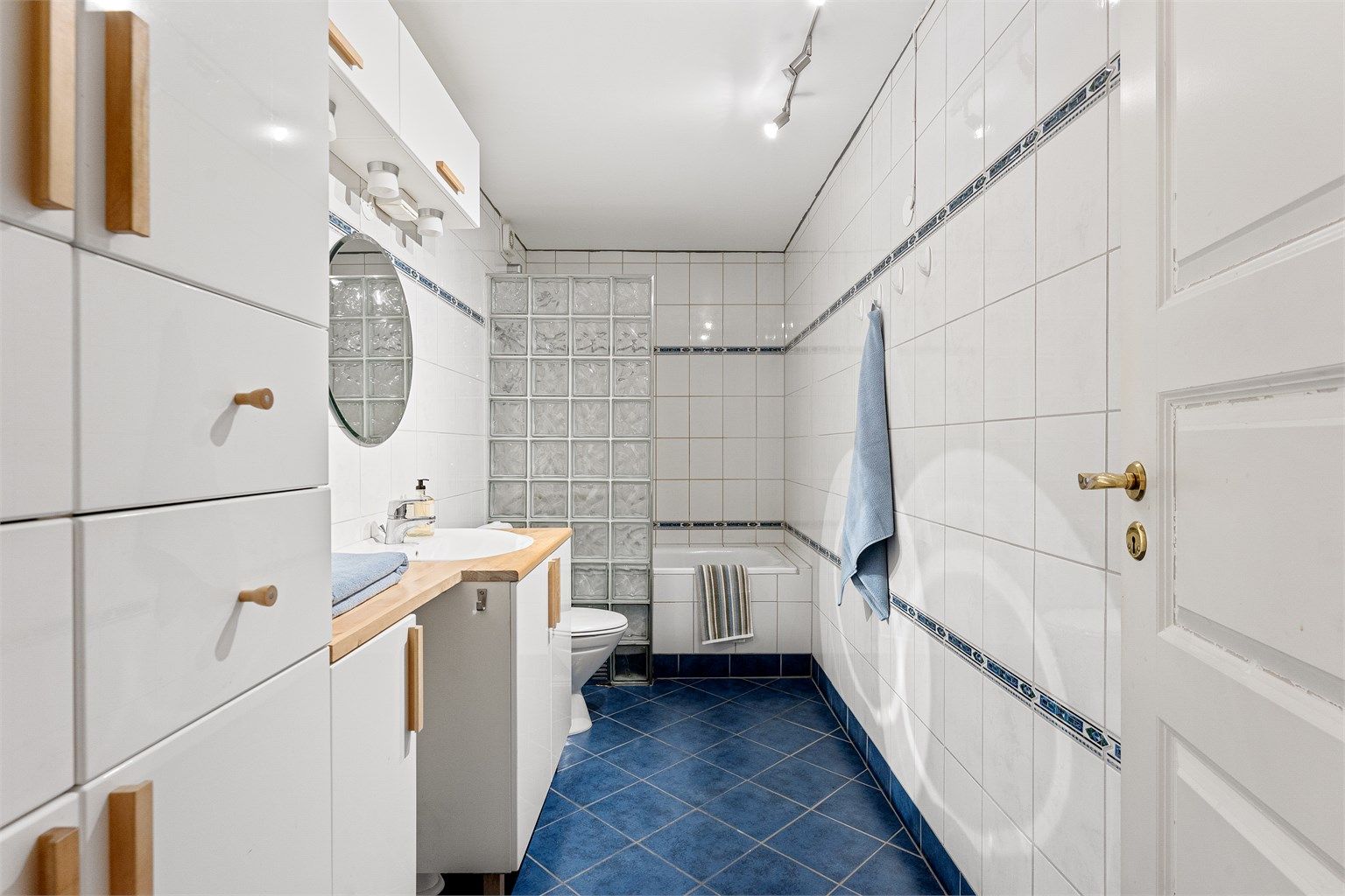 Hovedbadet er flislagt og utstyrt med badekar, servantinnredning og varmekabler i gulvet.