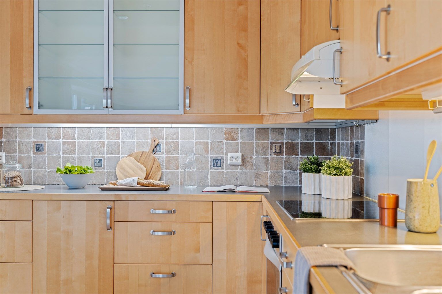 Kjøkkeninnredningen er fra byggeåret og har glatte fronter og laminert benkeplate.