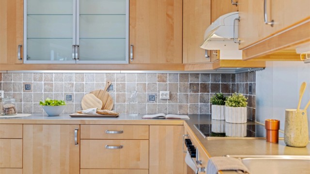 Kjøkkeninnredningen er fra byggeåret og har glatte fronter og laminert benkeplate.