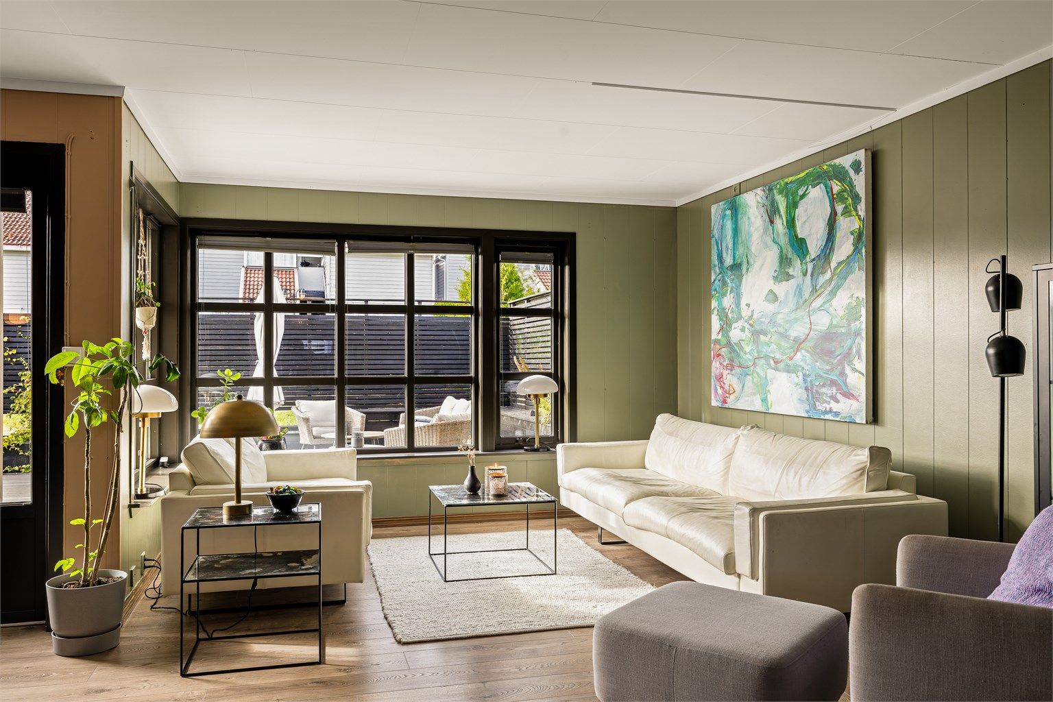 Stuen er malt i lyse og tidsriktige fargevalg. Gulv har pen laminat.