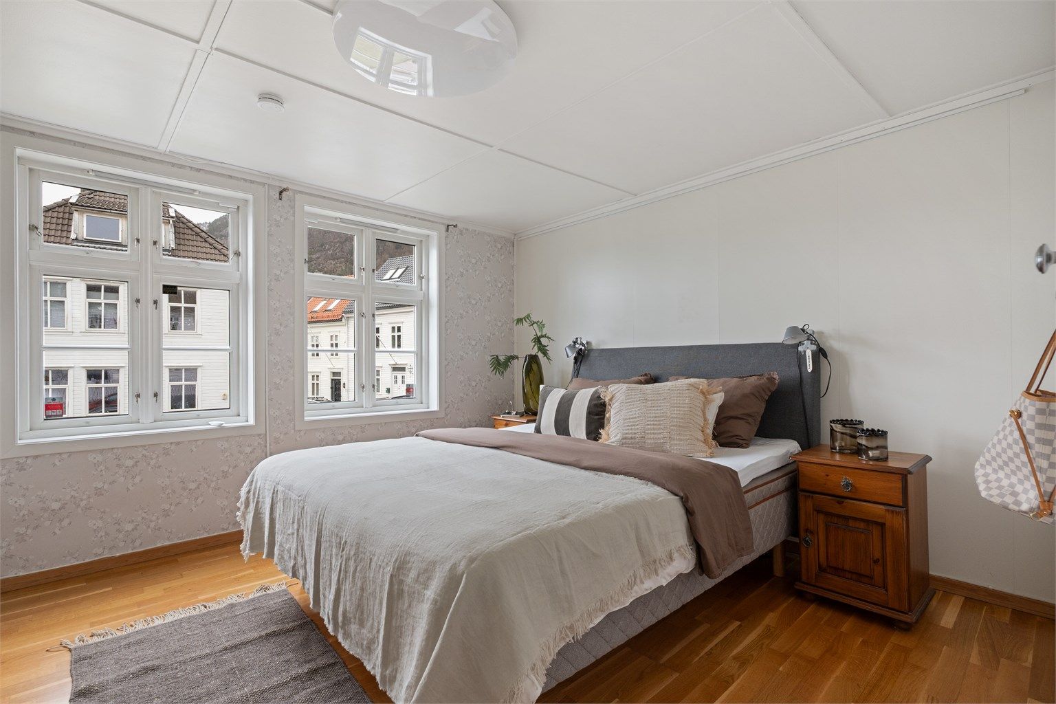 Rommet har godt lysinnslipp, tregulv og tapetsert fondvegg.