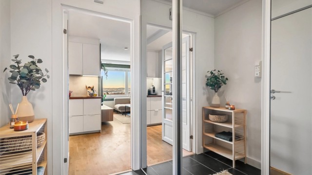 Entrè med fliser på gulv. Integrerte og plassbesparende garderobeløsninger