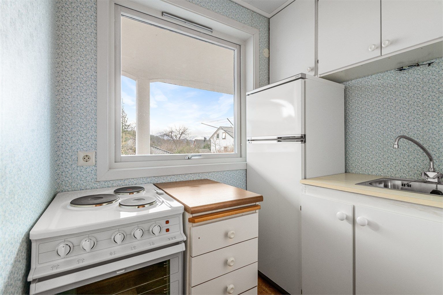 I underetasjen er det etablert et mindre tekjøkken med hvite, glatte fronter og laminatbenkeplate