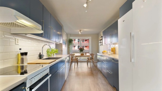 Pent kjøkken med spiseplass, og innredning med glatte fronter på skap og skuffer, benkeplate med laminert overflate og nedfelt kjøkkenvask