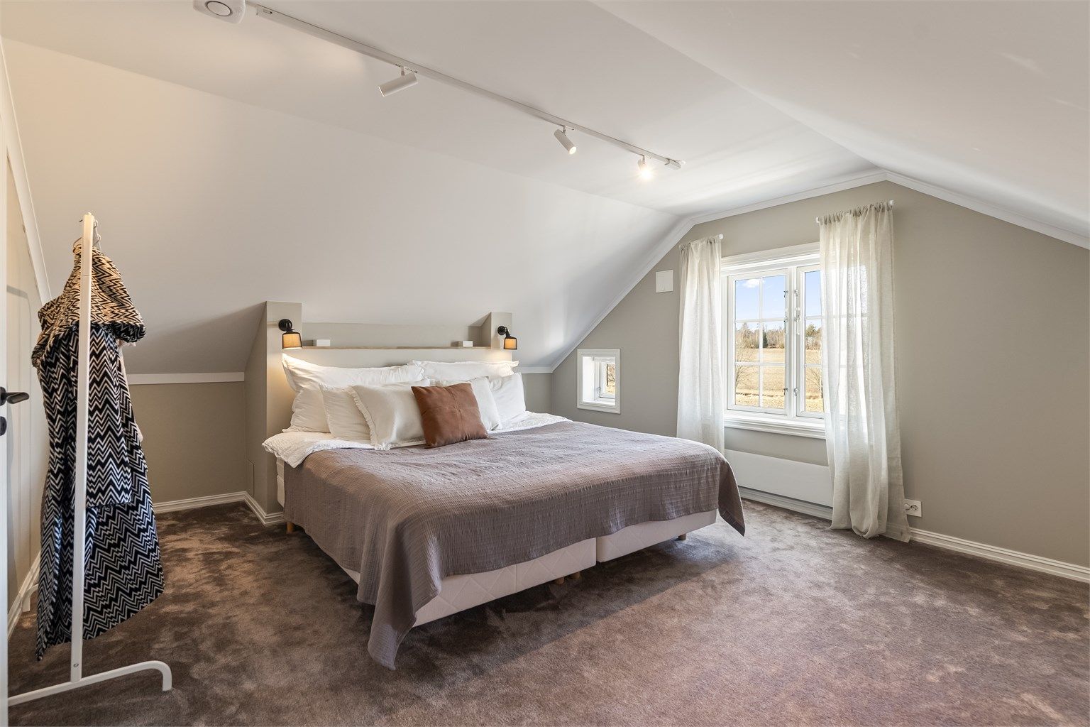 Hovedsoverommet i etasjen har vegg-til-vegg-teppe som gir en lun følelse.