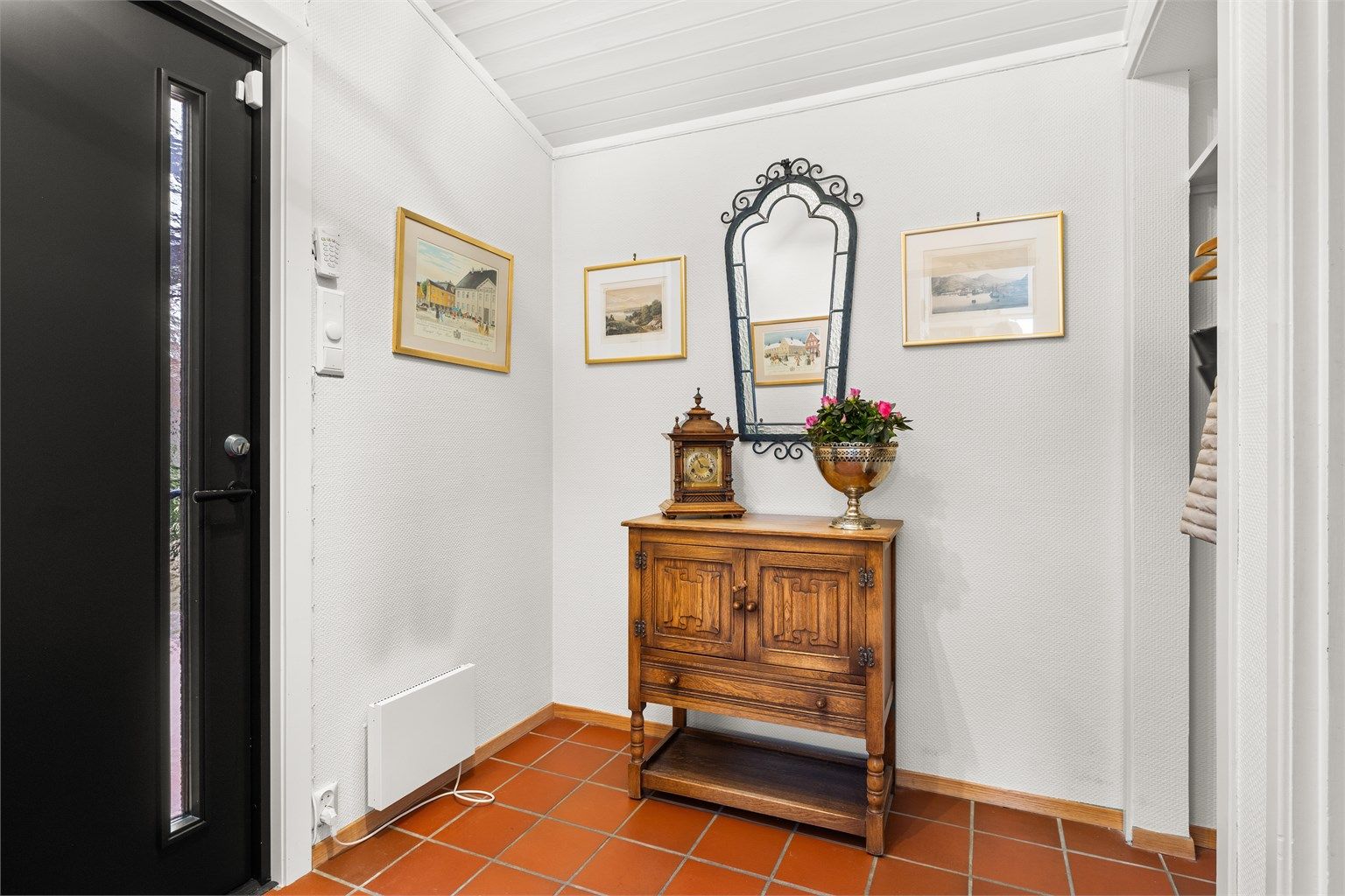 Inngangspartiet har flislagt gulv og en nyere entrédør fra 2022 som gir et godt førsteinntrykk.