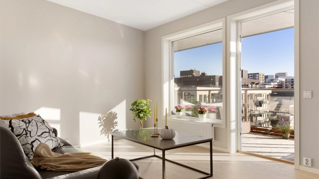 Store vindusflater og balkongdør slipper solen godt inn og gir stuen en lun og innbydende atmosfære. Rommet varmes opp med radiator tilkoblet felles varmesentral, noe som gir jevn og behagelig varme gjennom hele året.