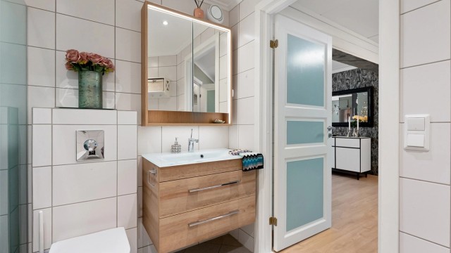 Bad er innredet med servant skap og speilskap fra 2024