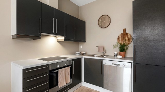 Moderne kjøkken med mørke, slette fronter og lys benkeplate i laminat