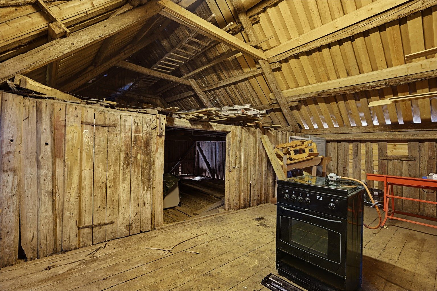 Overetasjen i låven tilbyr betydelig lagringskapasitet under den synlige trekonstruksjonen.