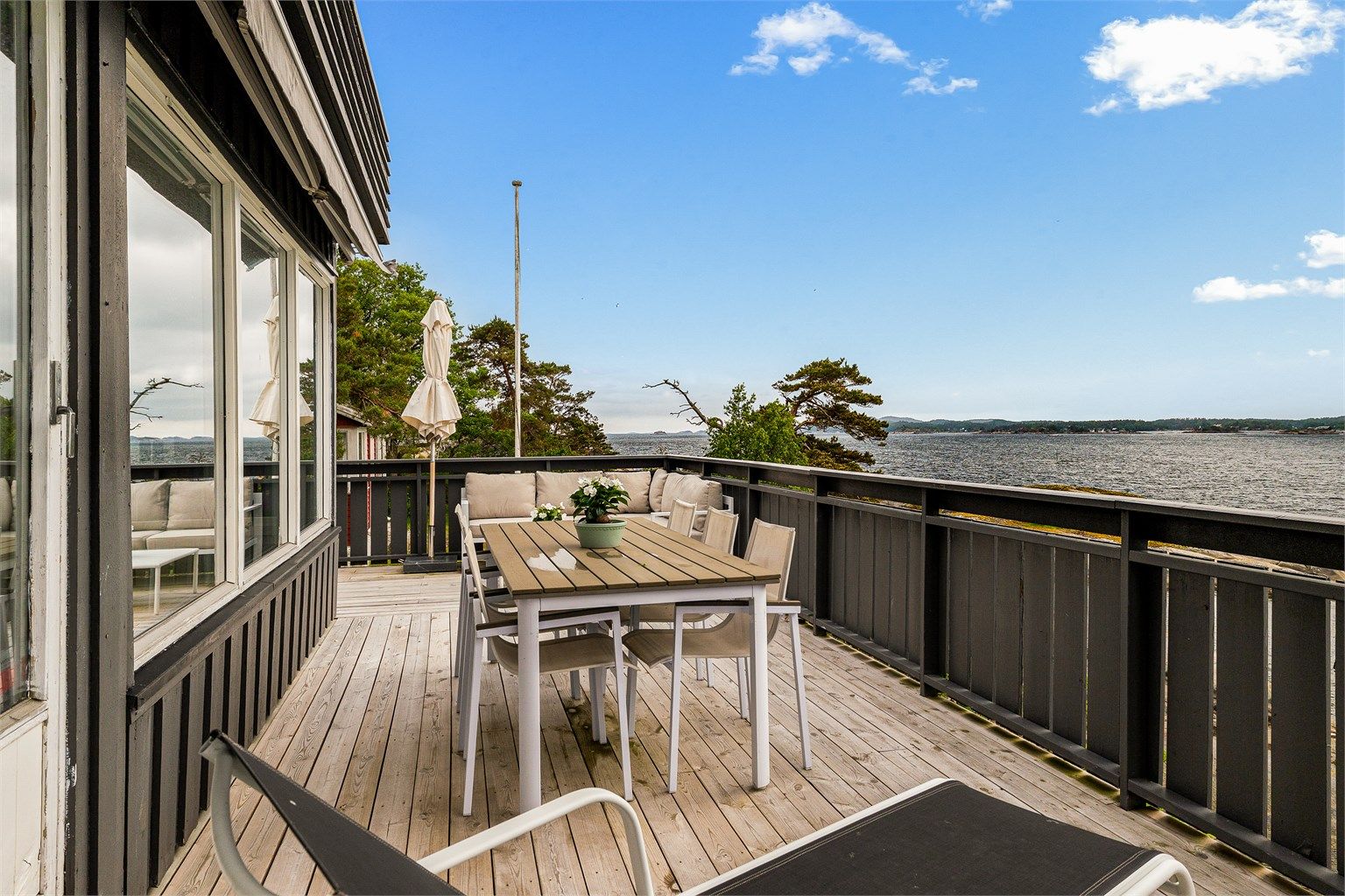 Terrassen har rikelig med plass til både stort langbord og egen sittegruppe. Her er det god plass til hele familien på en varm sommerdag.