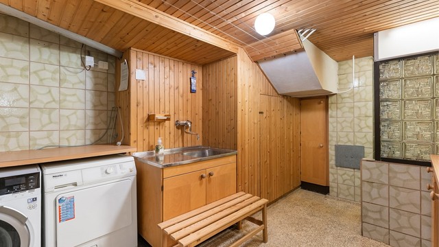 Stort vaskerom i kjelleren med opplegg for vaskemaskin og tørketrommel, samt en dusjsone.
