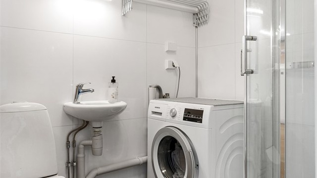 Badet har flislagt gulv med varme og baderomsplater på vegg samt opplegg for vaskemaskin. Videre er badet utstyrt med servant, toalett og dusjkabinett.