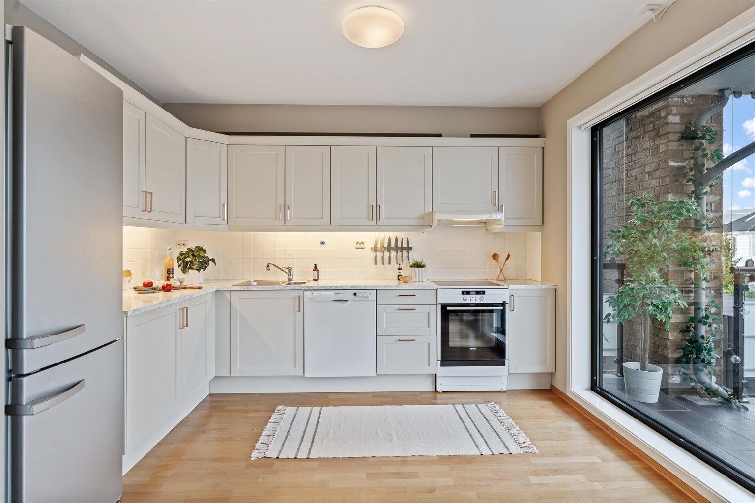 Kjøkkenet er utstyrt med frittstående hvitevarer, inkludert komfyr, oppvaskmaskin og kjøleskap, som alle medfølger.