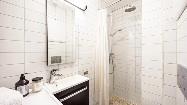Videre er det vegghengt toalett og dusjhjørne utstyrt med både hånddusj og regndusj samt opplegg for vaskemaskin.