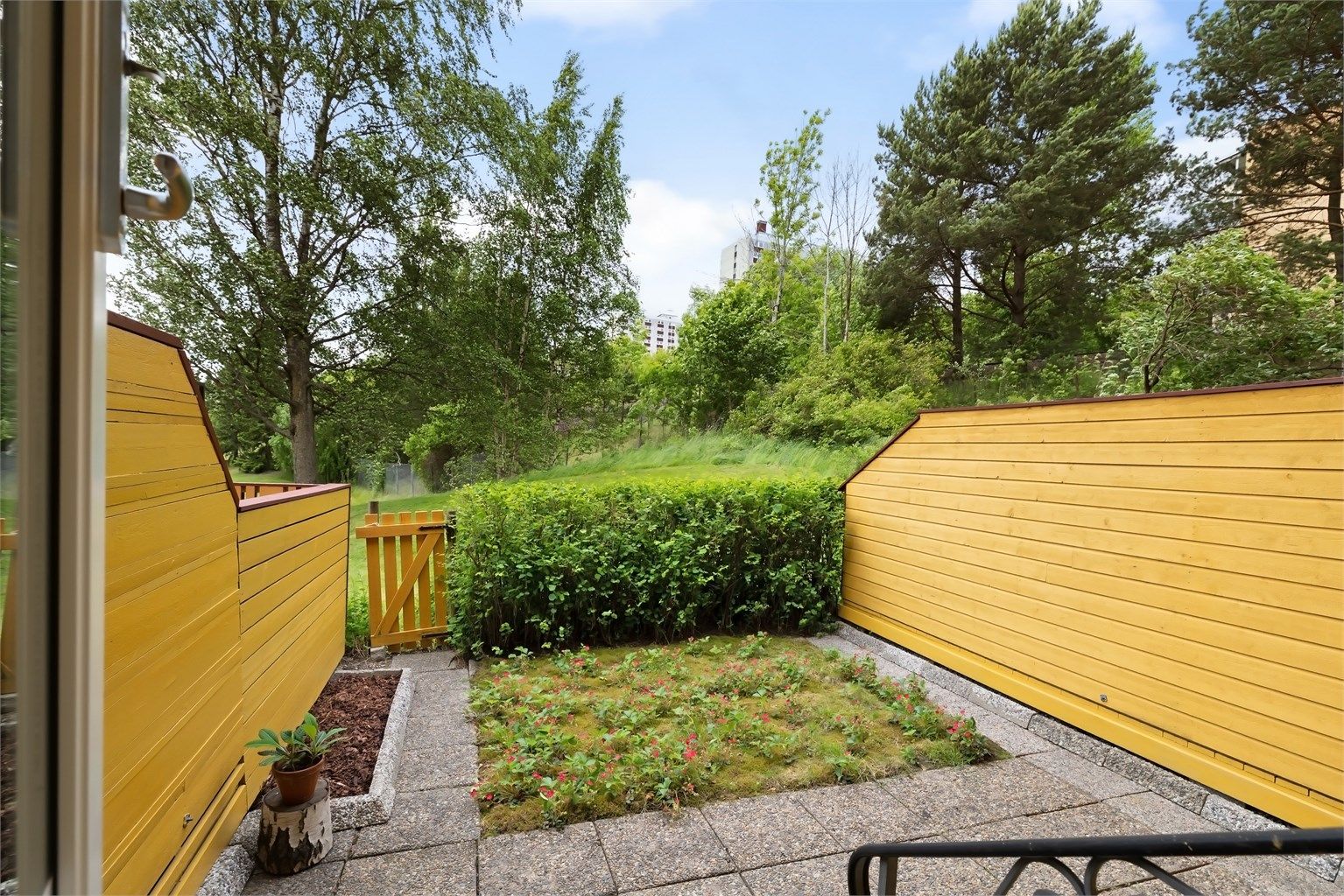 Flott usjenert markterrasse med en liten hageflekk.