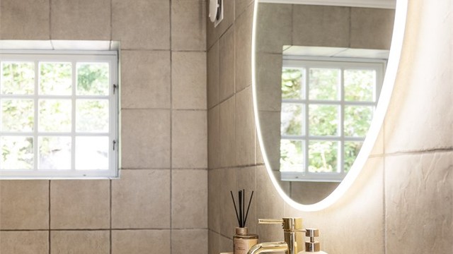 Baderom i hovedhuset med flislagt gulv med varme, downlights og innfliset badekar.
