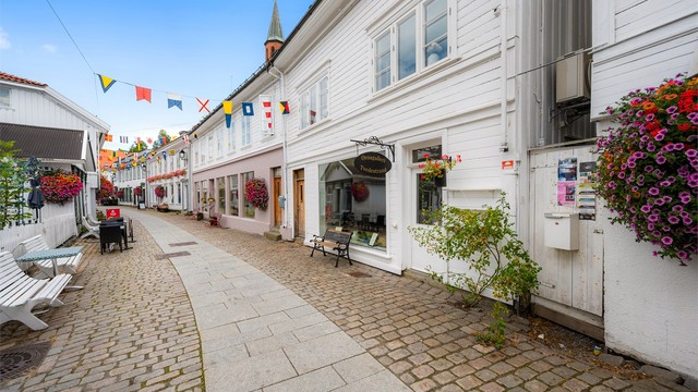 Beliggenhet i en sjarmerende gate med brostein og historisk bebyggelse. Fotograf: Thor Brobakken
