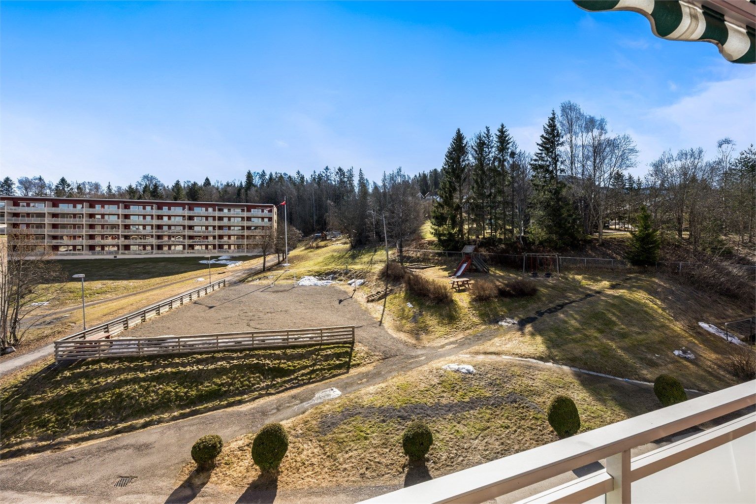 Fra balkongen ser man utover de store grøntområdene med leke- og ballplass.