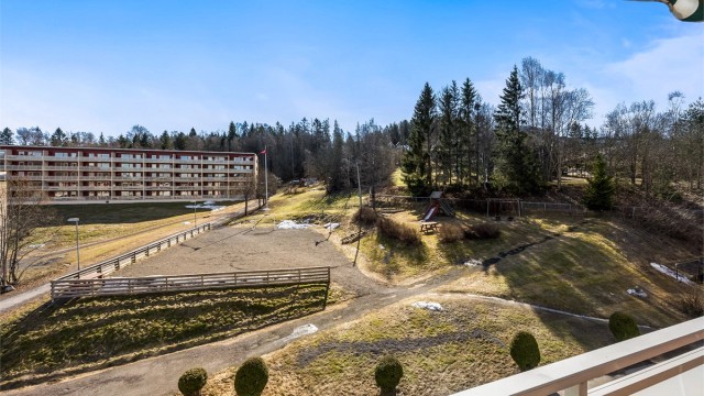 Fra balkongen ser man utover de store grøntområdene med leke- og ballplass.