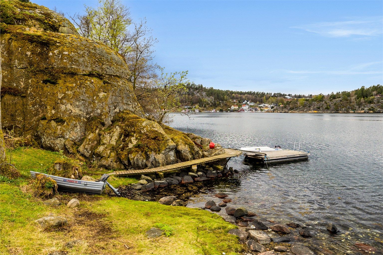 Fra hytta er det kun få meter til koselig strand og brygge som deles med Storholmen 18.