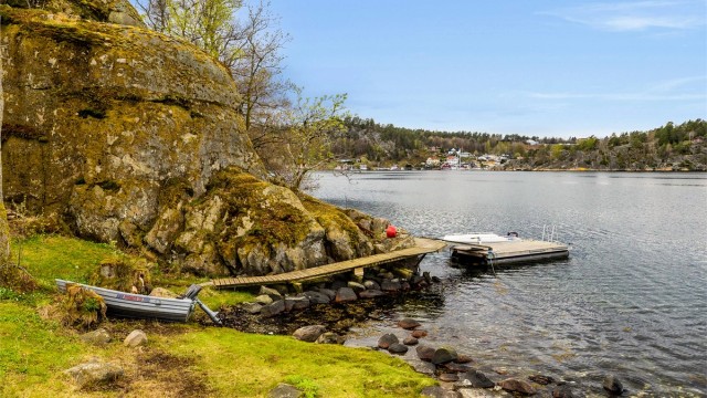 Fra hytta er det kun få meter til koselig strand og brygge som deles med Storholmen 18.