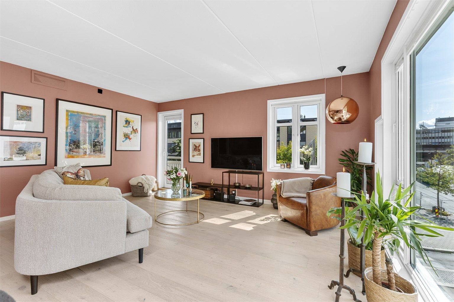 Lys og åpen stue- og kjøkkenløsning med store vindusflater som gir naturlig lys.