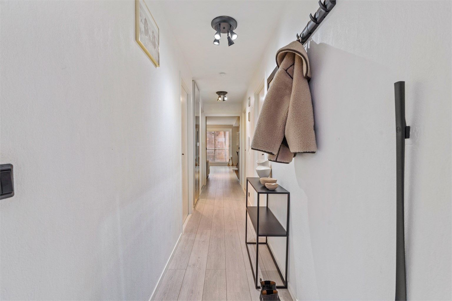 Entré med plass til å henge fra seg yttertøy. Fra entréen ledes du inn i boligen, som har gjennomgående laminatgulv i oppholdsrommene.