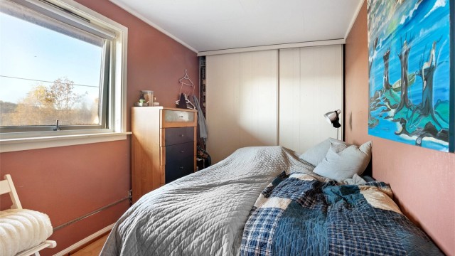 Soverom i utleiedelen med romslig skyvedørsgarderobe.
