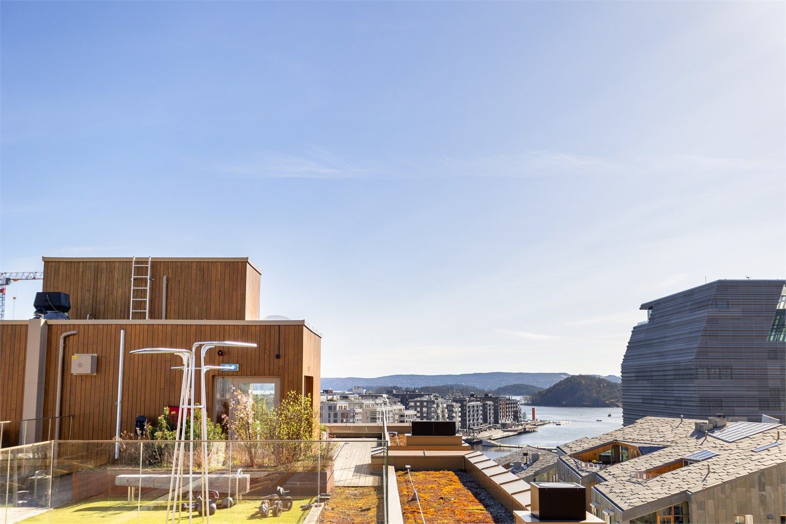 Takterrassen er pent opparbeidet med tredekke, beplantning og flere sittegrupper.