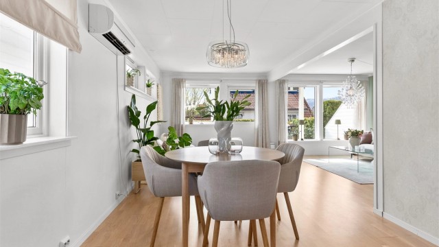 Spisestuen fungerer som et naturlig bindeledd mellom kjøkkenet og stuen, perfekt for sosiale sammenkomster