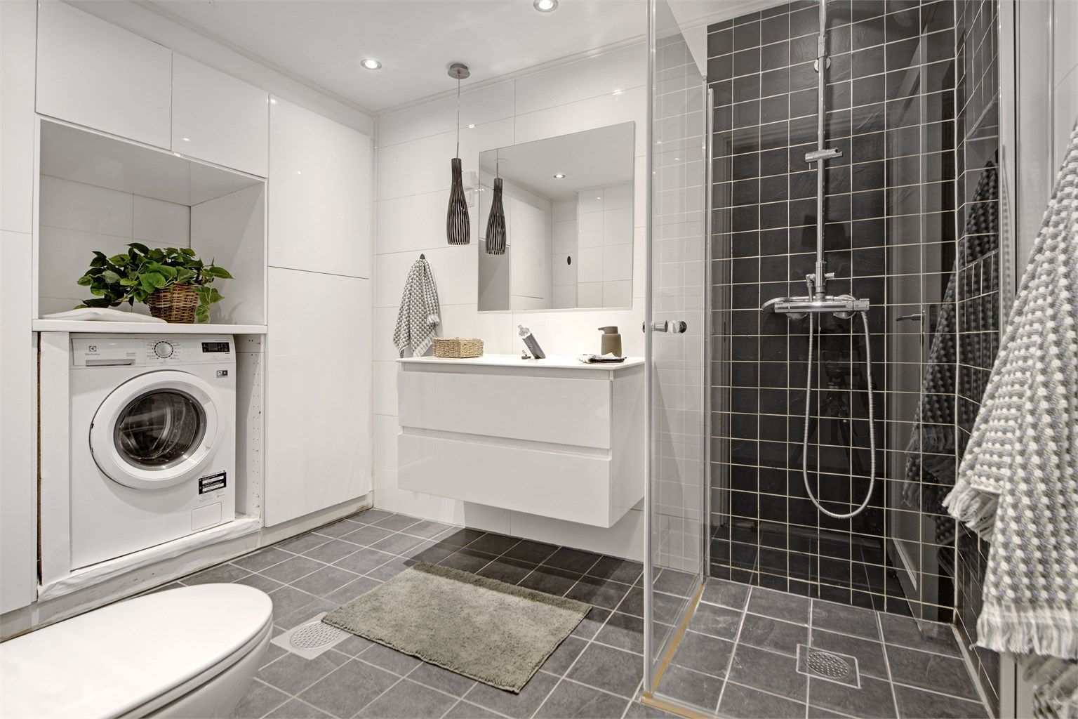 Bad - flislagt gulv med gulvvarme - flislagte vegger - downlights i himling - opplegg for vaskemaskin