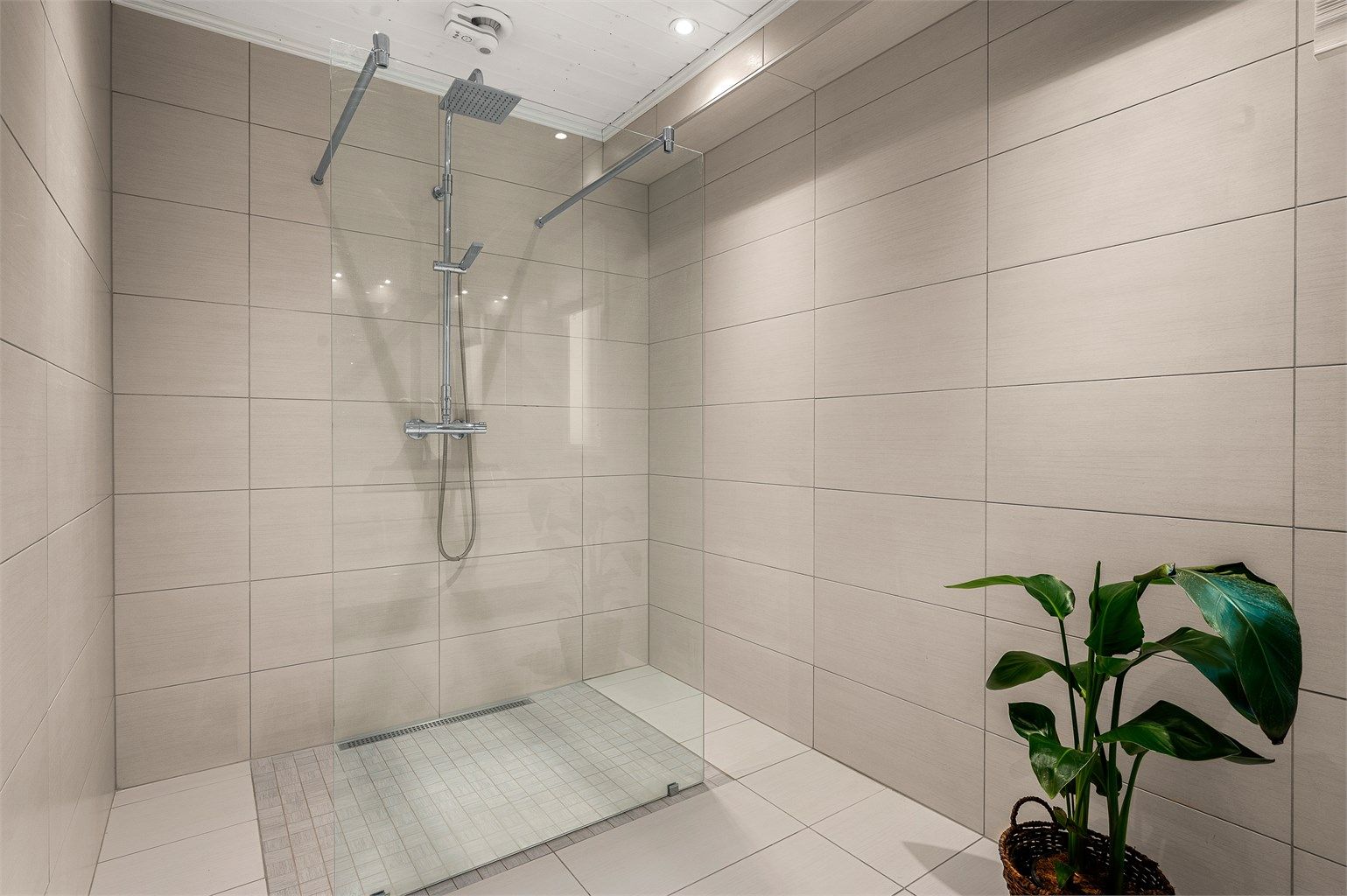 Romslig dusjsone, vegghengt toalett og moderne løsninger gir et stilrent og funksjonelt uttrykk.