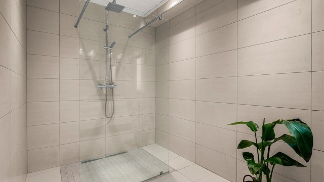 Romslig dusjsone, vegghengt toalett og moderne løsninger gir et stilrent og funksjonelt uttrykk.