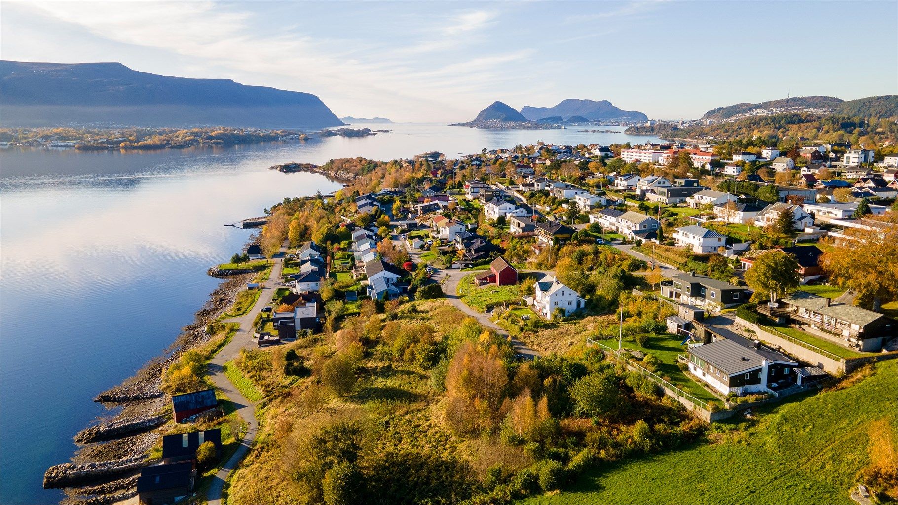 Dronebilde over tomten og nærområdet tatt fra øst mot vest