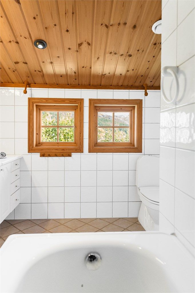 Vinduene på badet vender ut mot landskapet og slipper inn rikelig med lys.